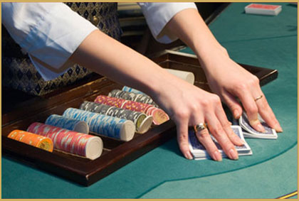 Uniformed croupier dealing blackjack at a hired casino table